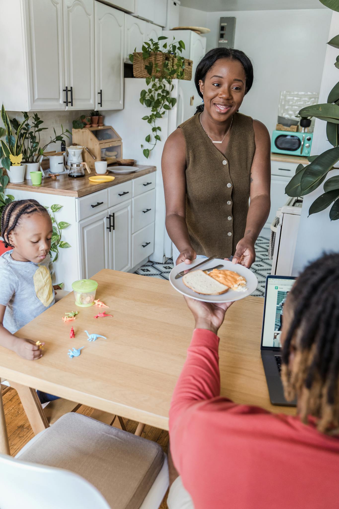 A mother serves breakfast to her family in a bright, modern kitchen. Joyful family moment.